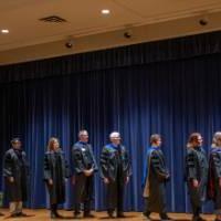 faculty line up on stage to receive their award